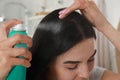 Woman applying dry shampoo onto her hair indoors, closeup Royalty Free Stock Photo