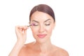 Woman applying eyelash serum essential oil on eyelashes with makeup mascara brush
