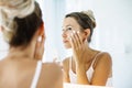 Woman applying face cream in bathroom Royalty Free Stock Photo