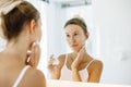 Woman applying face cream in bathroom Royalty Free Stock Photo