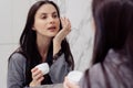 Woman applying face cream on undereye zone Royalty Free Stock Photo