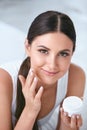 Woman Applying Facial Cream On Face Skin In White Interior Royalty Free Stock Photo