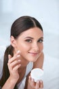 Woman Applying Facial Cream On Face Skin In White Interior Royalty Free Stock Photo