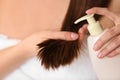 Woman applying hair conditioner, closeup.