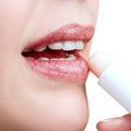 Woman applying hygienic lipbalm on lips with cracks. Royalty Free Stock Photo