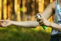 Woman applying insect and mosquito repellent spray on hand