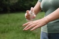 Woman applying insect repellent onto hand in park, closeup. Tick bites prevention Royalty Free Stock Photo