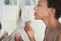 Woman Applying Lip Gloss In Mirror At Home Royalty Free Stock Photo