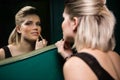 Woman applying lips gloss while looking at mirror Royalty Free Stock Photo