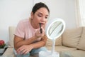 Woman applying lipstick in front of mirror Royalty Free Stock Photo
