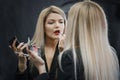 Woman applying lipstick looking to the mirror Royalty Free Stock Photo