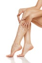 Woman applying lotion on her long legs Royalty Free Stock Photo