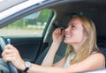 Woman applying make-up while driving car. Royalty Free Stock Photo