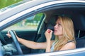 Woman applying make-up while driving car. Royalty Free Stock Photo