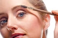 Woman applying make-up using eyebrow brush