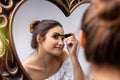 Woman applying makeup beauty product, putting makeup mascara in the mirror, at home, morning routine. Beautiful lady Royalty Free Stock Photo