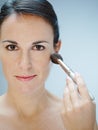 Woman applying makeup with brush Royalty Free Stock Photo