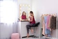 Woman applying makeup near mirror with light bulbs Royalty Free Stock Photo