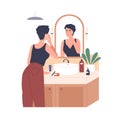 Woman applying moisturizing cream in front of mirror in bathroom. Skincare, beauty routine. Female caring about face