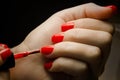 Woman applying nail polish on her manicured nail carefully