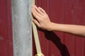 A woman is applying painter`s tape, masking tape on the fence to paint a fence post to mask off areas that should not be painted Royalty Free Stock Photo