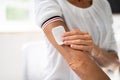 Woman Applying Patch On Her Arm