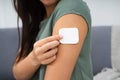 Woman Applying Patch On Her Arm Royalty Free Stock Photo