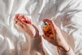 Woman applying perfume on her hand in morning light