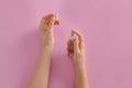 Woman applying perfume on pink background Royalty Free Stock Photo