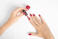 Woman applying red nail gel polish. closeup of hand of a young woman with long red manicure on nails Royalty Free Stock Photo