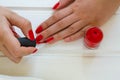 Woman applying red nail polish manicure. Female hand