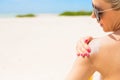 Woman applying sunscreen at the beach on hot summer day