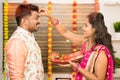 Woman applying Thilaka or Mark to his partner or husband`s forehead during Karwa Chauth festival celebration while both