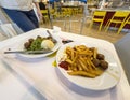 Woman Approaches IKEA Dining: Fries, Meatballs and Peas