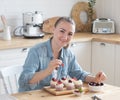 Young woman pastry chef decorates cupcakes with berries Royalty Free Stock Photo