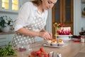 Woman in an apron decorates cupcakes with strawberries Royalty Free Stock Photo