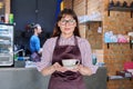 Woman in apron, food service coffee shop worker, small business owner with cup of coffee Royalty Free Stock Photo