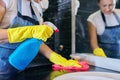 Woman in apron gloves with detergent washing wash basin