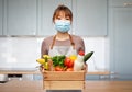 woman in apron in mask with food in wooden box Royalty Free Stock Photo