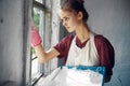 woman in apron painter repair painting window Royalty Free Stock Photo