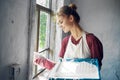 woman in apron painter repair painting window Royalty Free Stock Photo