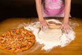 Woman in apron preparing pizza on table