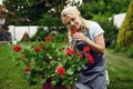 Woman in apron smelling flowers in the garden