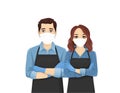 Young man and woman in aprons and protective masks