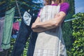 Woman in apron standing by clothes line Royalty Free Stock Photo