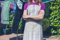 Woman in apron standing by clothes line Royalty Free Stock Photo