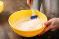 Woman in apron stir the dough on wooden table