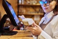 Woman worker manager of restaurant holding wireless banuov payment terminal