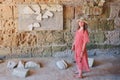 A woman among the archaeological site Anthony terms, board with latin inscriptions. The ruins of Carthage antique times of the