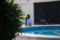 Woman architect sitting on a fountain resting and examining the plans of the houses. The woman is held from behind for the photo.